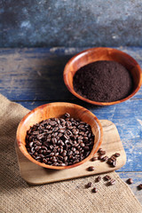 Coffee beans in wooden cup on rustic wooden table with a blank space for a text, Coffee in cup on loft background