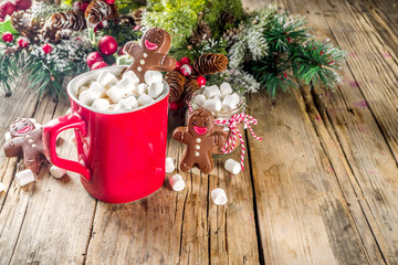 Christmas hot chocolate red mug with melted chocolate gingerbread man. Funny Christmas drink for holidays. With xmas decoration copy space