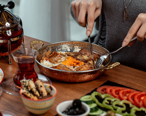 woman eating omelette with black tea