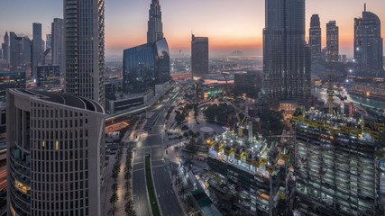 Panoramic skyline view of Dubai downtown before sunrise with mall, fountains and skyscrapers aerial night to day timelapse