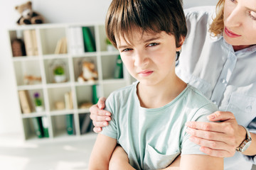 Obraz premium cropped view of child psychologist hugging kid with dyslexia
