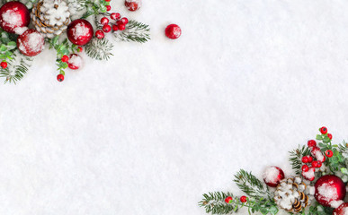 Christmas decoration. Frame of cones pine, twigs christmas tree, red balls, red berries on snow...