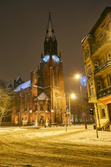 Fototapeta na wymiar Facade and belfry of a neo-Gothic church during the winter in Poznan.