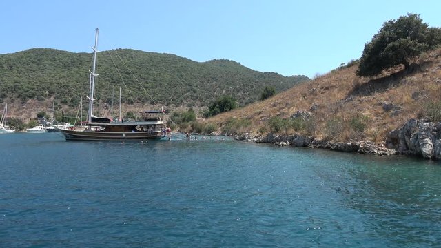Tersane Bay, Fethiye, Turkey - 30th of July 2019: 4K Tourist on the boat trip have fun in the sea