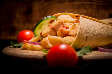 caesar roll close up. wooden background. juicy tomatoes in the foreground