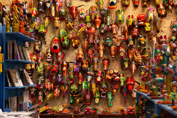 wall full of hand-painted colored masks - craft market in Antigua Guatemala - traditional colors of Guatemala