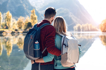 Two travel hikers in love enjoying the nature while looking the landscape in front of the lake in mountain. © nenetus