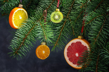 Fototapeta na wymiar Christmas tree decorated with fruits of kiwi fruit grapefruit, orange, and clementine. Healthy food and nutrition.