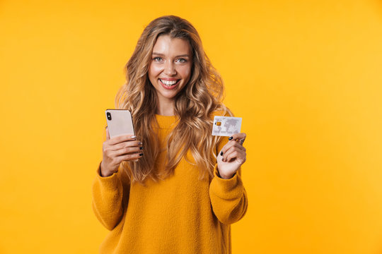 Image of caucasian blonde woman holding credit card and cellphone