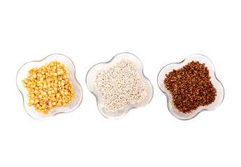 Isolated creamers with buckwheat, pearl and pea groats on white background. Top view