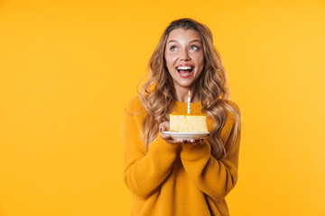 Image of happy woman smiling and holding birthday cake with candle