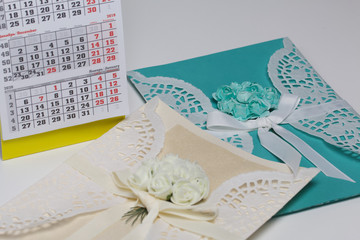 Handmade greeting cards made of paper. Decorated with braid flowers. Nearby is a fragment of the calendar with the month of December.