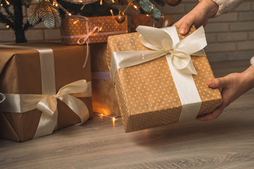 father male hands taking gift under Christmas tree in holidays eve morning miracle time for children 