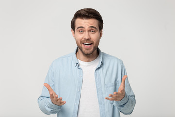 Surprised millennial man feel amazed isolated in studio