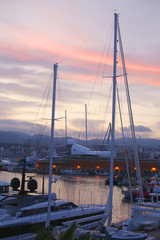 Beautiful evening view with yachts at harbor. Amazing dusk sky with pink clouds. 