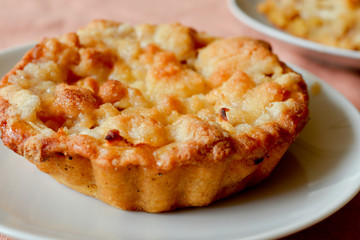 Apple crumble dessert on a white plate. Shallow DOF