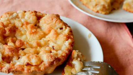 Apple crumble dessert on a white plate close-up. Shallow DOF