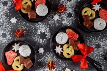 Top view of mini iron skillets. Christmas cookie, chocolate and candy.