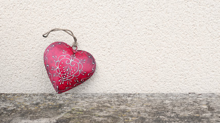 Red heart with white ornament on a light wall background. Love, wedding and Valentine's Day concept. Copy space