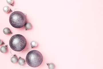Christmas greeting card composition. Christmas silver balls on pink pastel background. Flat lay, top view, copy space