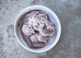 Melting chocolate ice cream in a white ceramic cup