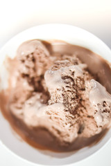 Melting chocolate ice cream in a white ceramic cup