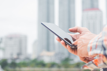 close up business man using hand typing smartphones and touch screen working search with app devices outdoor in city with sunrise and building background. 5G technology connecting the world.