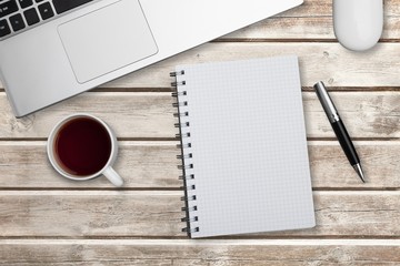 Modern workplace with laptop, notebook, pen and cup of coffee