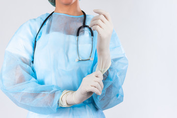Female doctor surgeon preparing for the surgical operation, she is wearing gloves and scrubs,...