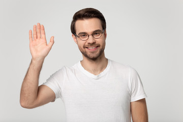 Smiling man in glasses wave hand say hello to audience