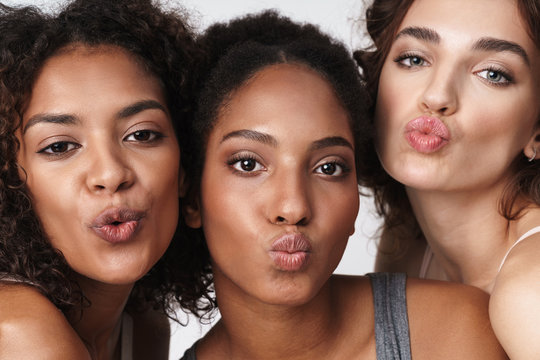 Portrait of multiracial women standing together and making kiss faces