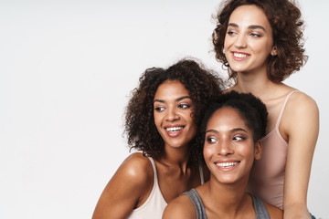 Portrait of three cheerful multiracial women smiling and looking aside