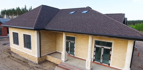 Bituminous tile for a roof. House with a roof from a bituminous tile. a roof from a bituminous tile. Moder