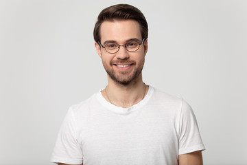 Headshot portrait of smiling man in glasses on studio background