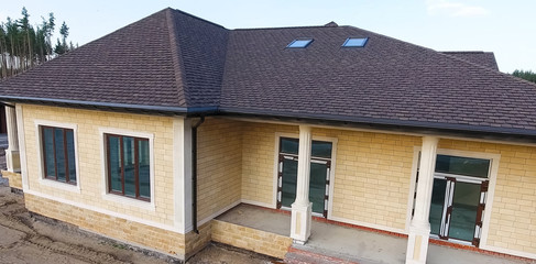 Bituminous tile for a roof. House with a roof from a bituminous tile. a roof from a bituminous tile. Moder