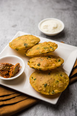 Methi Poori or Puri made using Fresh fenugreek leaves missed with wheat flour, by making small pancake size shapes deep fried in oil, served with tea
