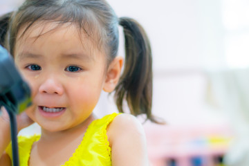 An Asian kindergarten little girl is crying.