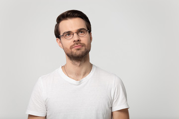 Fototapeta premium Pensive man in glasses look up considering sale offer