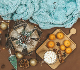 New Year flat lay with golden gift,balls,lights,cones,cinnamon and anice star,caramel on a brown background