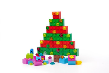 Christmas tree made of plastic bricks on white background © Tatsiana