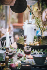 Decorated greenhouse in trendy christmas setting with dinner table, candles and christmas lights.