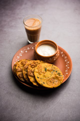 Methi Poori or Puri made using Fresh fenugreek leaves missed with wheat flour, by making small pancake size shapes deep fried in oil, served with tea