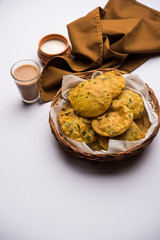 Methi Poori or Puri made using Fresh fenugreek leaves missed with wheat flour, by making small pancake size shapes deep fried in oil, served with tea