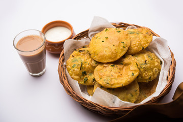 Methi Poori or Puri made using Fresh fenugreek leaves missed with wheat flour, by making small pancake size shapes deep fried in oil, served with tea