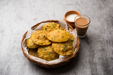 Methi Poori or Puri made using Fresh fenugreek leaves missed with wheat flour, by making small pancake size shapes deep fried in oil, served with tea