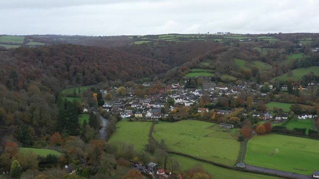 Wide aerial orbit of the small market town of Dulverton, with the River Barle meandering through the valley on the edge of Exmoor, UK.