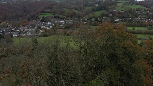 Aerial rising reveal shot of the small market town of Dulverton and the River Barle on the edge of Exmoor, UK.