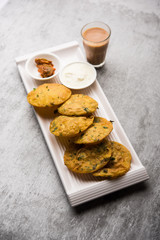Methi Poori or Puri made using Fresh fenugreek leaves missed with wheat flour, by making small pancake size shapes deep fried in oil, served with tea