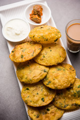 Methi Poori or Puri made using Fresh fenugreek leaves missed with wheat flour, by making small pancake size shapes deep fried in oil, served with tea