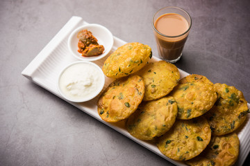 Methi Poori or Puri made using Fresh fenugreek leaves missed with wheat flour, by making small pancake size shapes deep fried in oil, served with tea